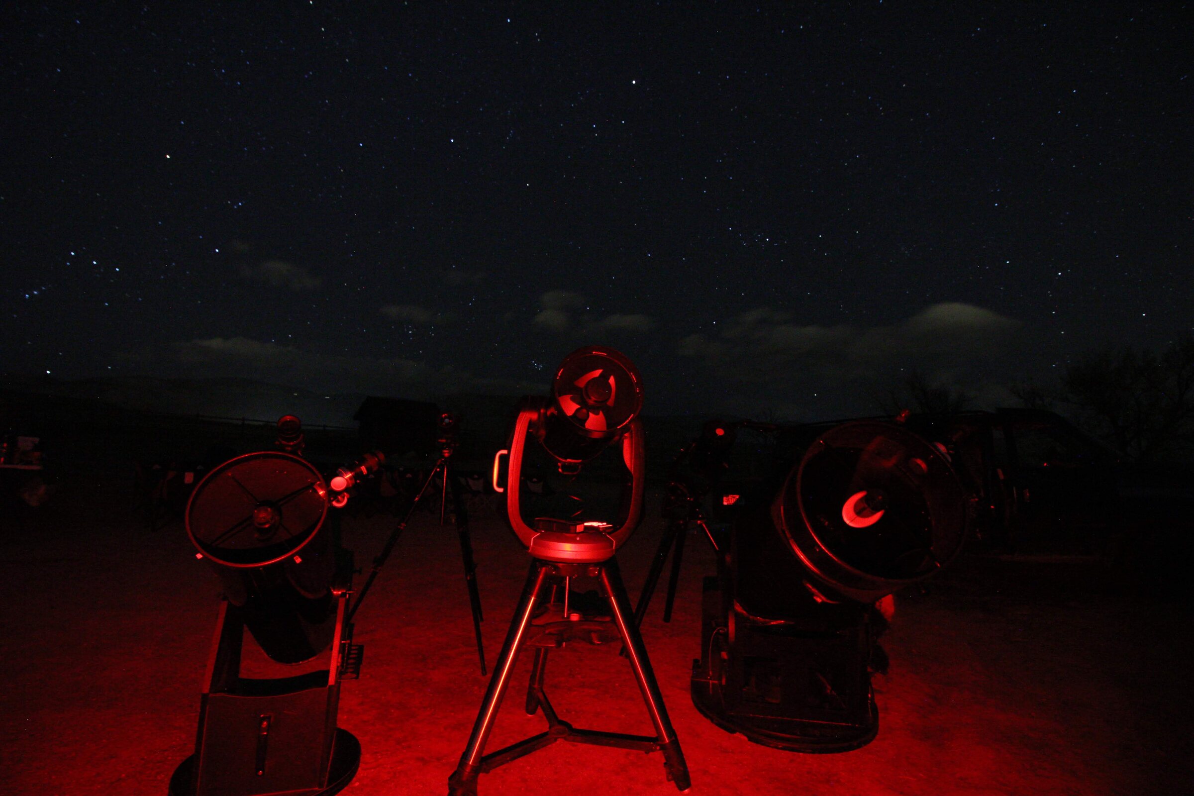 Red-lit telescopes beneath a starry Colorado sky