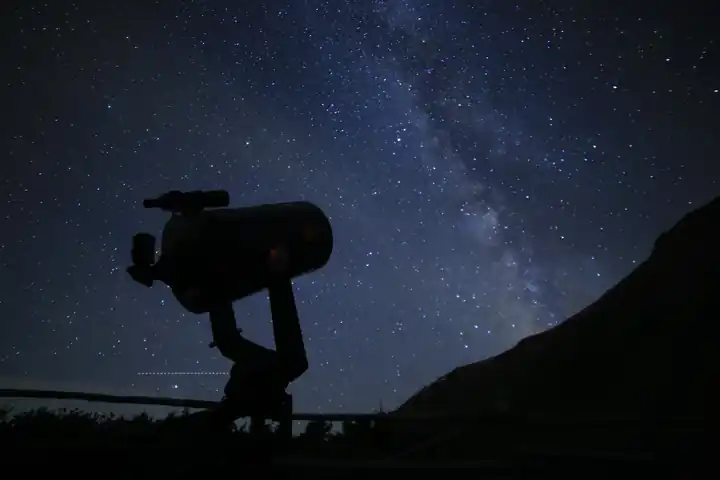A telescope set against a dense Milky Way sky in Western Colorado, photographed by AstroTours.org.